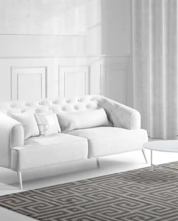 a living room with a bed and a chair in front of a window